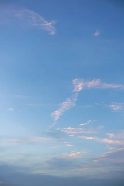 Gökyüzünün sakin bir görüntüsü, atmosfer sahnesinde huzur içinde süzülen yumuşak, narin beyaz ve pembe bulutlarla tepeden açık pembe ve mor renge doğru bir gradyanı gösteriyor.