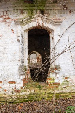 Beyaz tuğladan yapılmış terk edilmiş eski bir kilisenin penceresi.