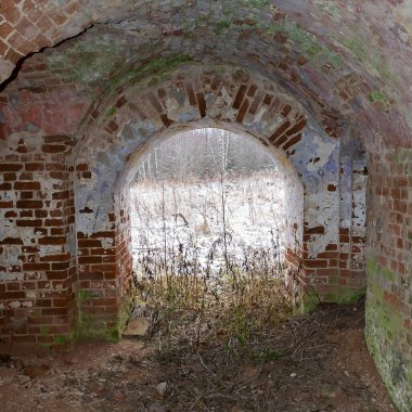 Terk edilmiş bir kilisenin içinde kemerler, eski kırmızı tuğla duvarlar.