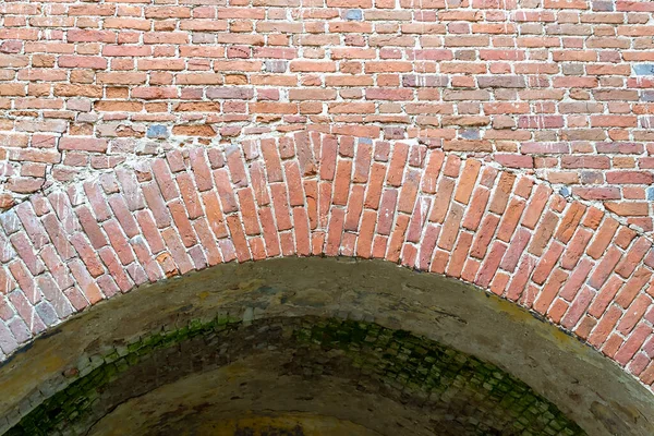 an old red brick arch in an abandoned church