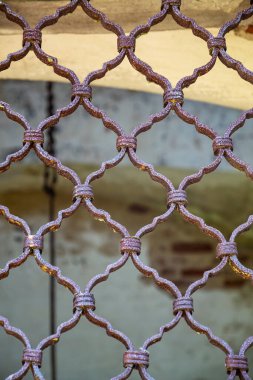 Eski, paslı metal pencere ızgarası.