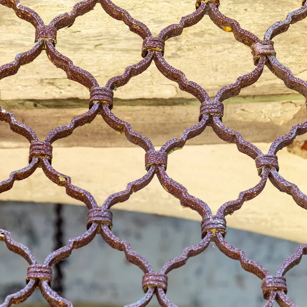 an old, rust-covered metal window grate