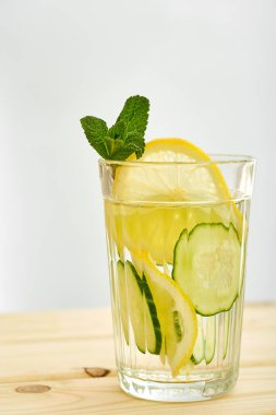 Tahta bir masada salatalık ve limonla ferahlatıcı bir limonata.