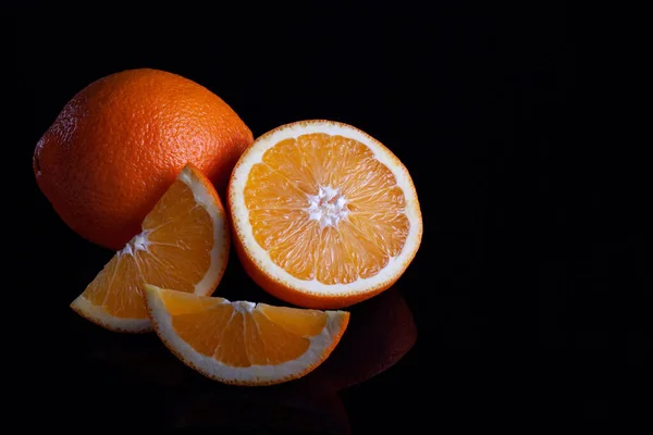 Fruit orange sur fond réfléchissant noir — Photo