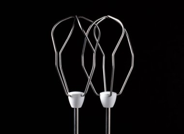 İki karıştırıcı hamur ve çırpılmış yumurta çırpma pozisyonu. El çırpma makinesinin karanlık arka planda çekilmiş bir parçası.