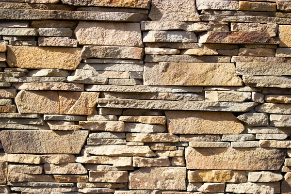 Sarı bir taş duvar örüyor.