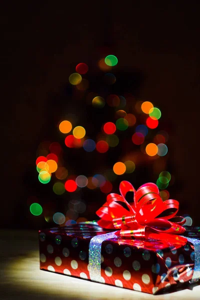 Gift box against the background of multicolored lights