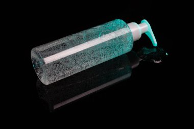 Makyaj malzemesi çıkarmak için kozmetik ürün. Cyan gradyan renkli sıvı ve küçük hava kabarcıkları. Şişe ve şeker kutusu. Karanlık yüzey arkaplanına dökülen sıvı.