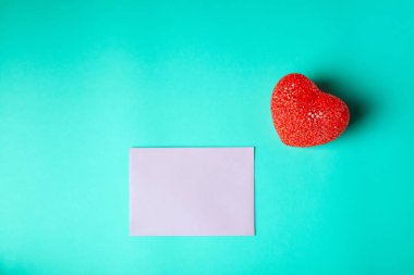 Turkuaz arka planda kırmızı kalpli boş pembe tebrik kartı.