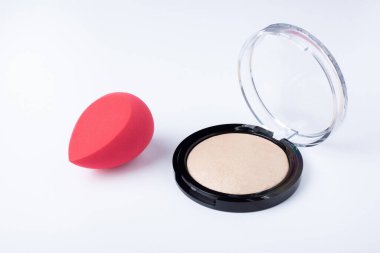 Beyaz arka planda kozmetik tozu ve sünger