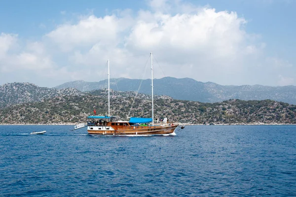 海でヨットをお楽しみください。波に乗ってトルコの旗帆をボード上の人々と観光船。高速移動遊覧船. — ストック写真