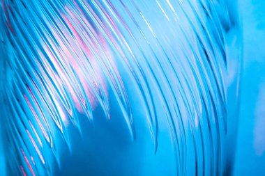 Soyut cam arka plan. Dalgalı cam dokusu çok renkli ışıkla aydınlatılmış. Pembe ve mavi lekeler. Kapatın. Camdaki fişekler