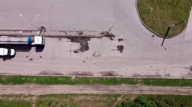 Büyük süt ya da su tankı kamyonu daha küçük bir otomobil tankıyla doldurulur. Benzin nakliyesi. Yakıt ikmali için hava görüntüsü. Otoparkta.