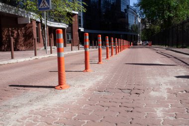 Yansıtıcı boya şeritli turuncu kazık. Trafik sıkışık. Yol tabelası. Trafik emniyeti. Hız limiti. Boş sokak.
