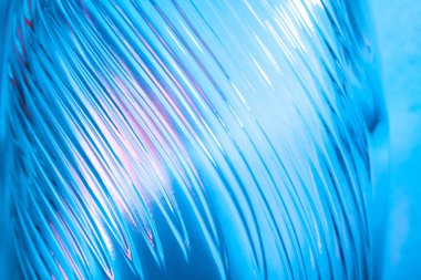 Soyut cam arka plan. Dalgalı cam dokusu çok renkli ışıkla aydınlatılmış. Pembe ve mavi lekeler. Kapatın. Camdaki fişekler