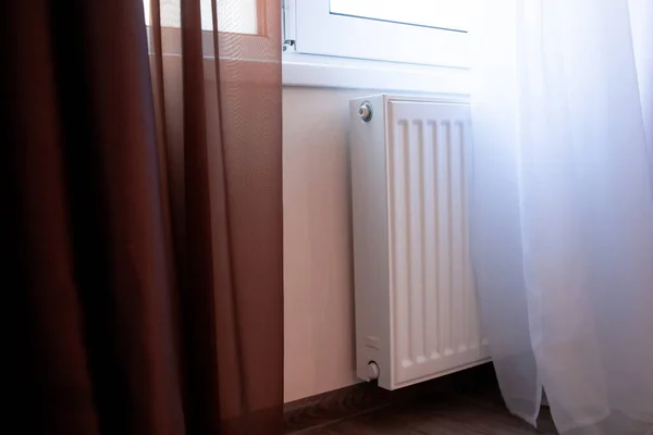 Oturma odasında beyaz kalorifer var. Ev için bireysel ısıtma sistemi. Ekonomi