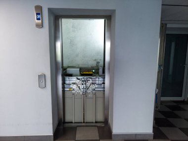 Asansör bakım altında. Asansör boşluğundaki kırık asansör. Servis dışı çelik asansör..