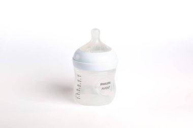 Bir Philips Avent bebek şişesi düz beyaz bir yüzeye oturur. Şişe boş, tasarım ve ölçüm işaretlerini açıkça gösteriyor. Etrafta başka nesne yok..