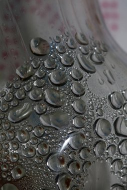 Şeffaf şişedeki su damlaları modern arka plandaki yüksek kaliteli baskıyı kapatır