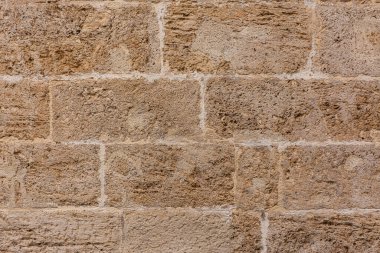 Eski desenli sarı taş blok duvar bir kalıp oluşturuyor. Tasarım veya reklam için arkaplan