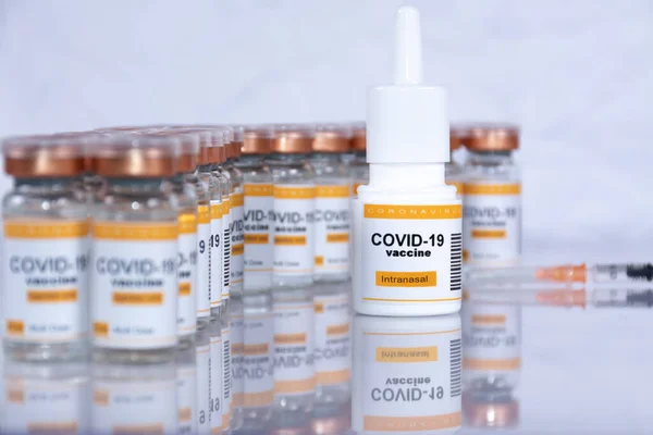 Solunum cihazında intranasal kullanım için Coronavirus aşısı. Arka planda odak dışı şişeler ve şırıngalar var. Laboratuvar ya da sağlık merkezi gibi görünüyor.