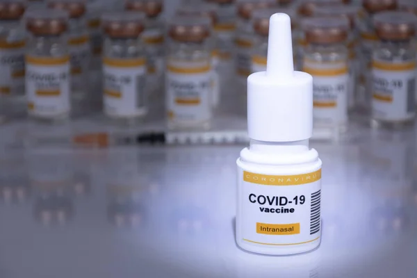 Solunum cihazında intranasal kullanım için Coronavirus aşısı. Arka planda odak dışı şişeler ve şırınga var. Laboratuvar gibi görünüyor.