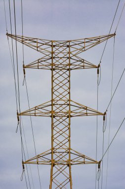 Yüksek gerilim kulesinin arka planında açık gökyüzü olan simetrik görüntüsü