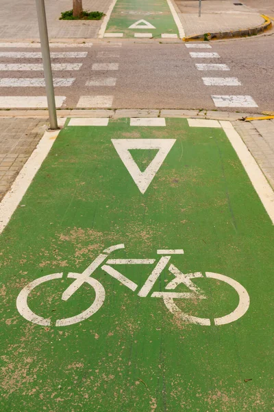 Green bike lane with bicycle and yield sign in a crossroad in the street