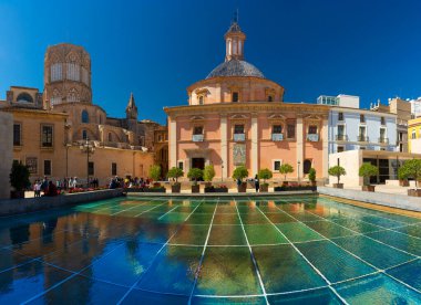 Valencia, İspanya, 14 Mart 2021 'de Terkedilmiş Meryem Ana' nın Kraliyet Bazilikası 'nın arka kapısı, katedralin kubbesinin yanında. Ön planda, arkeoloji müzesinin su kaplı çatısı