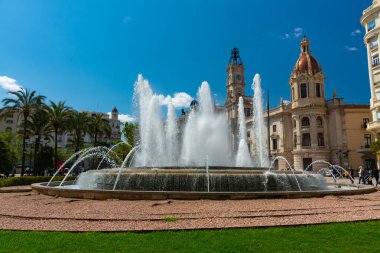 Valencia, İspanya, 17 Nisan 2021: Valencia, İspanya, 17 Nisan 2021: Belediye Binası ve onun saat kulesi, ana meydanda, küçük bir bahçede büyük bir fıskiye ile