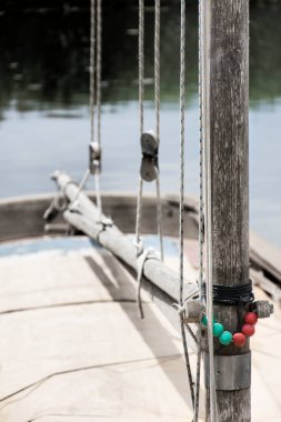 Yelkenli küçük bir teknenin direği ve bumbası, halatlar ve makaralarla.