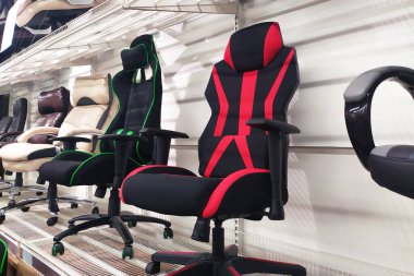 Mobilya mağazasında farklı bilgisayar oyunları oynayan yumuşak ergonomik sandalyeler.