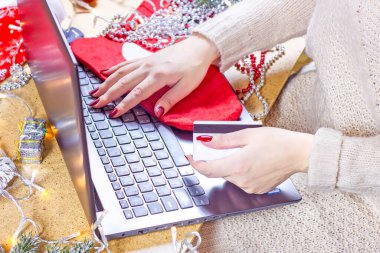 Noel ve Yeni Yıl dekorasyonlarında bir kadının elinde dizüstü bilgisayar vardı. Çevrimiçi alışveriş ve Xmas hediye alma kavramı.