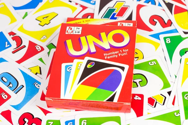 muitos cartões de jogo uno coloridos sobre fundo vermelho. uno é