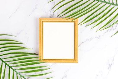 Kartlar, posterler ve tablolar için boş bir şablon olarak arka planda doğal dekorasyonları, dalları ve yaprakları olan retro ahşap fotoğraf çerçevesinin üst görünümü.