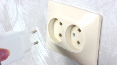 Beyaz kadın elleri elektrik prizini aç. Elektrik prizine tak. Kapat.