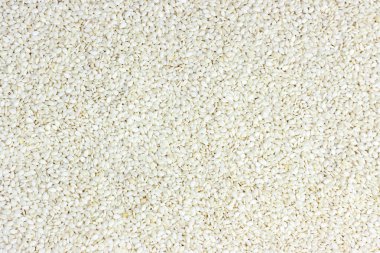 Besin arkaplanı olarak beyaz susam tohumlarının üst görünümü.