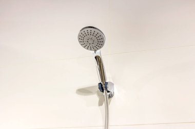 Banyodaki seramik duvarda yeni parlak metal duş başlığı..