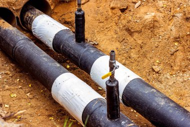 Isıtma ve su tedarik ağının dağıtım ünitesinin kurulumu. Toprak çukurundaki boruları bağlamak için çerçeve.