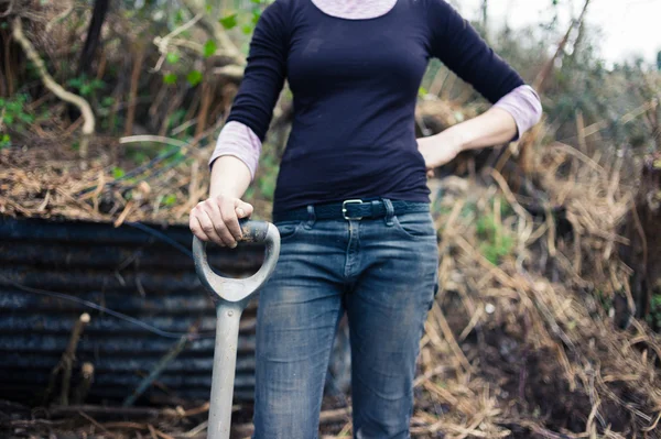 Young woman resting hand on spade — Stock Photo, Image