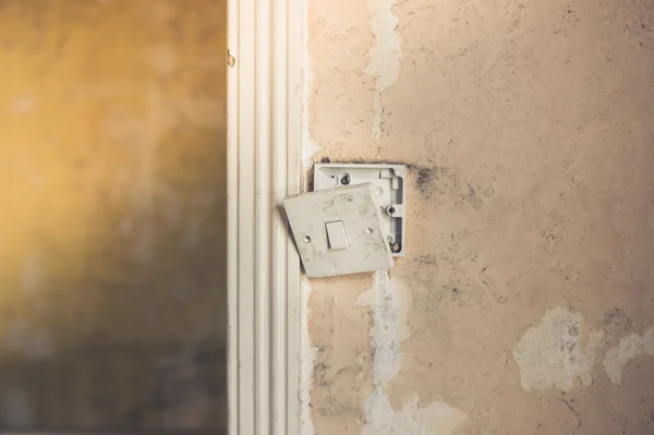 Interrupteur lumineux cassé sur un mur sale — Photo
