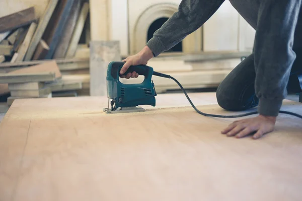 Junger Arbeiter schneidet Holz mit der Jochsäge — Stockfoto