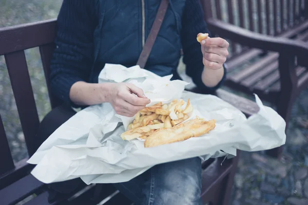 Kvinna äta fish and chips — Stockfoto