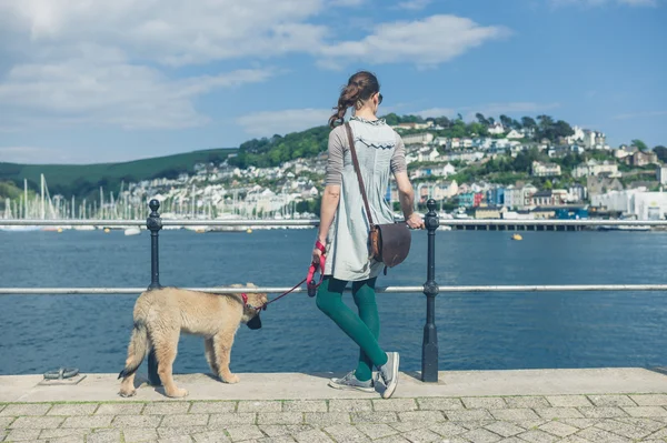 Mujer joven con Leonberger cachorro de pie junto al agua —  Fotos de Stock