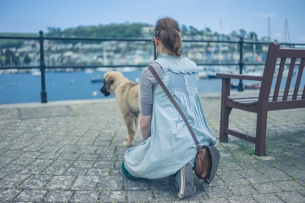 Yyoung woman sitting in street with her puppy — Stock Photo, Image