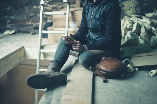 Young woman using cell phone in loft space — Stock Photo, Image