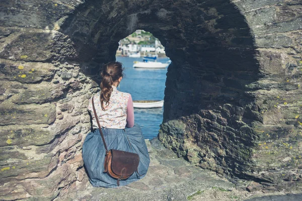 Una Joven Relaja Bajo Arco Piedra Junto Mar —  Fotos de Stock