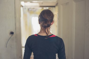 Genç bir kadın bir kapı çerçeve yenilenmiş bir evde duruyor