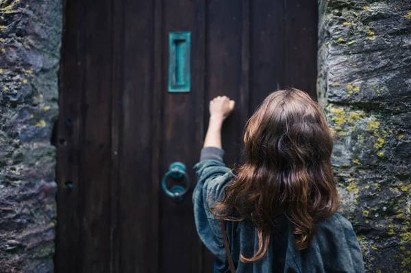 Een Jonge Vrouw Klopt Een Oude Houten Deur — Stockfoto