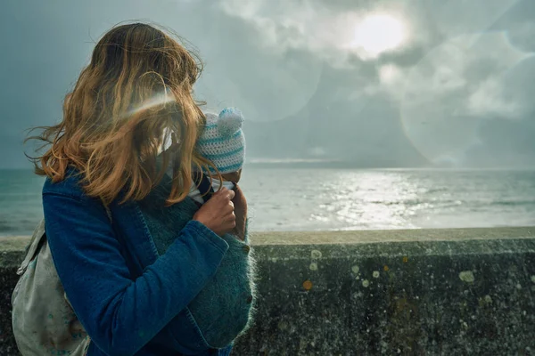 一位年轻的母亲 带着她的孩子 站在海边 凝视着一堵墙 — 图库照片